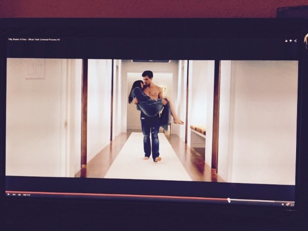 Wenn Christian Grey seine Ana nicht gerade mit Pfauenfedern verwemst, trägt er sie auf Händen. Foto: Screenshot aus dem Trailer zu "Fifty Shades of Grey" / Universal Pictures